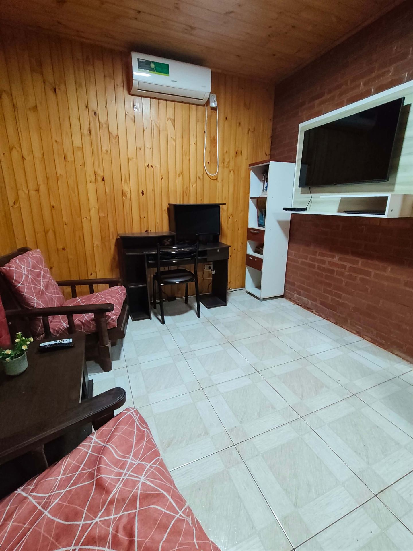 Living con sillones, TV y aire acondicionado
