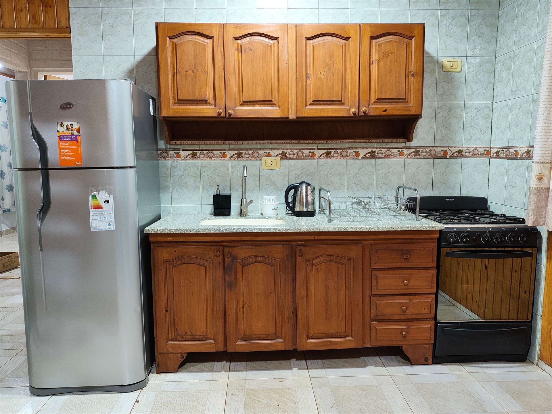 Cocina equipada con heladera y mesada completa