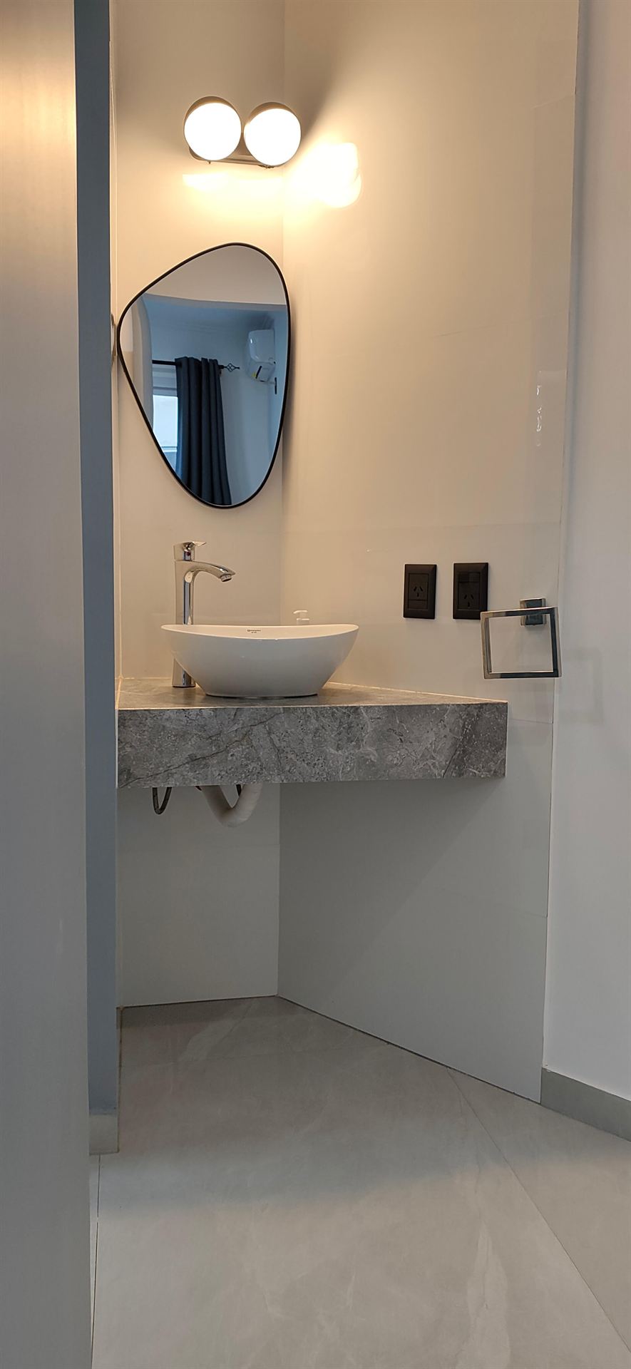 Baño con espejo redondo y bacha
