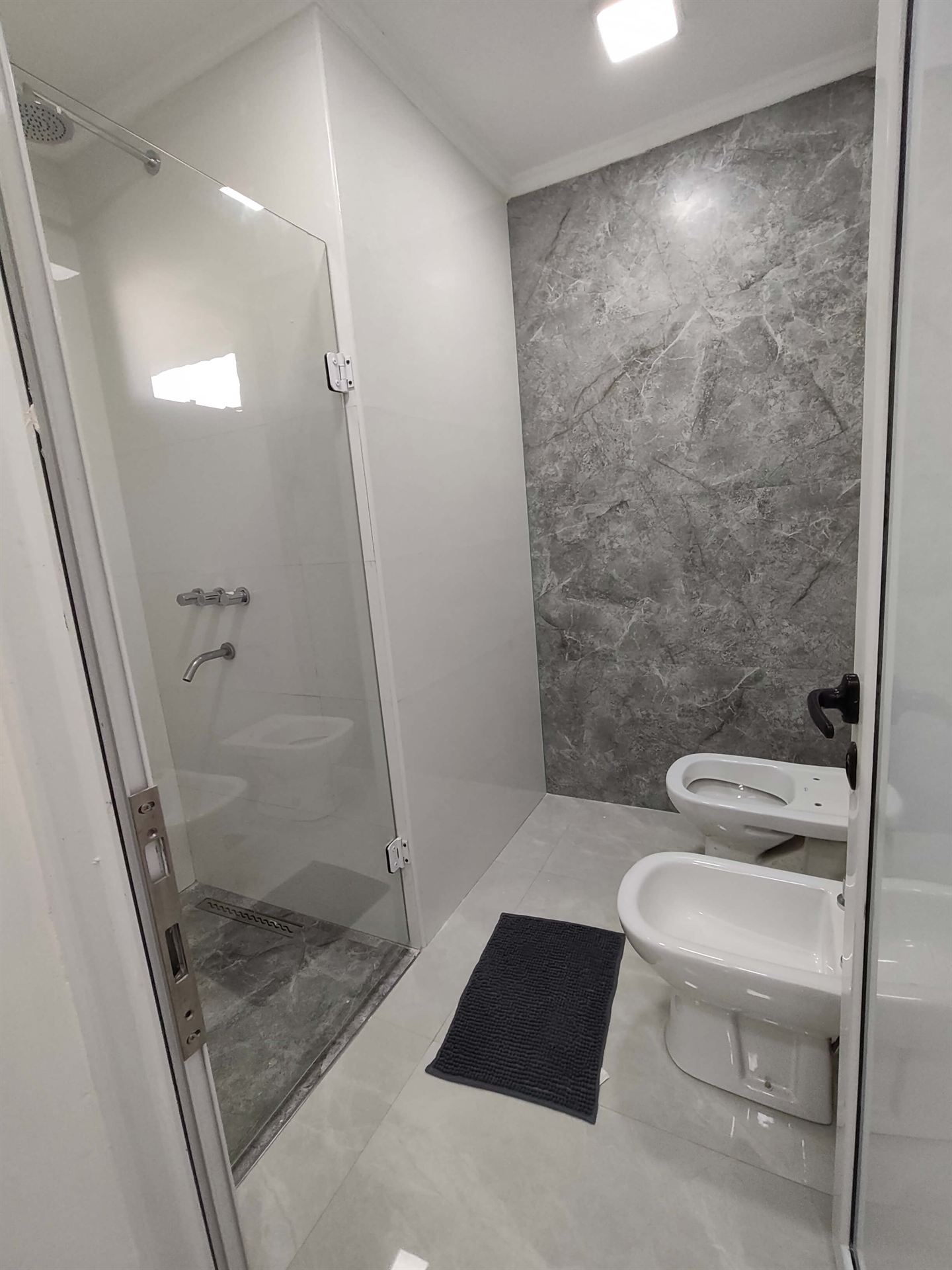 Baño completo con pared de mármol